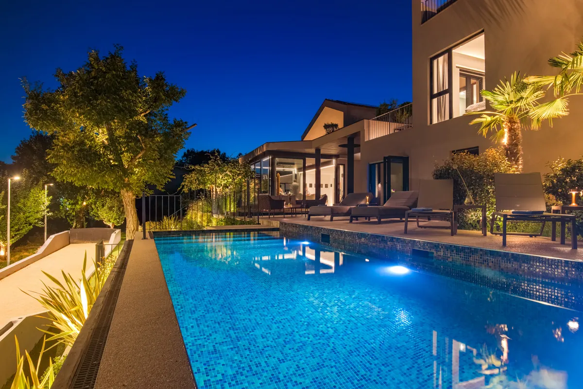 Casa Meline pool at night — illuminated heated pool with villa facade reflected in water