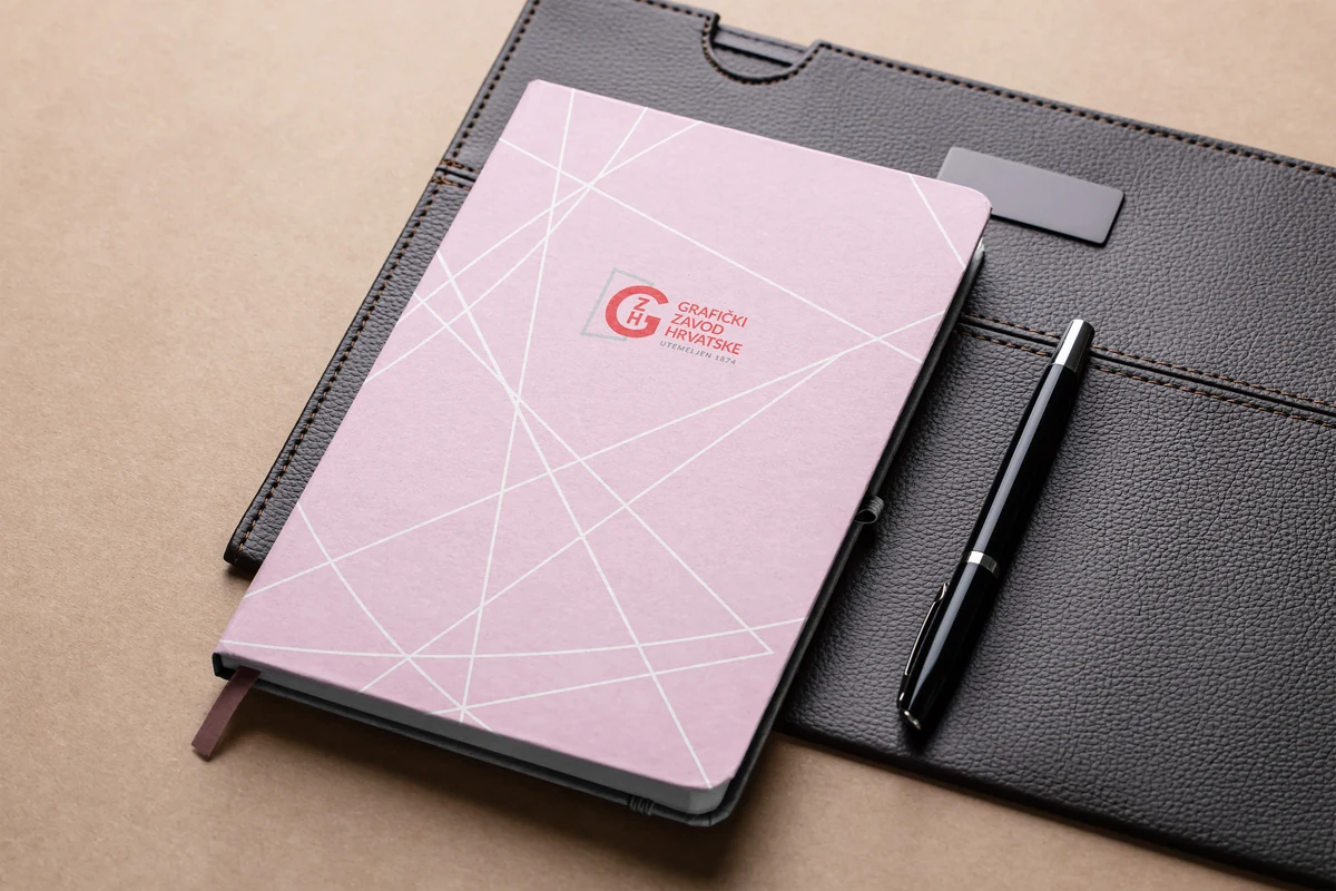 GZH branded corporate notebook pink — geometric line pattern with GZH monogram in red, black portfolio holder