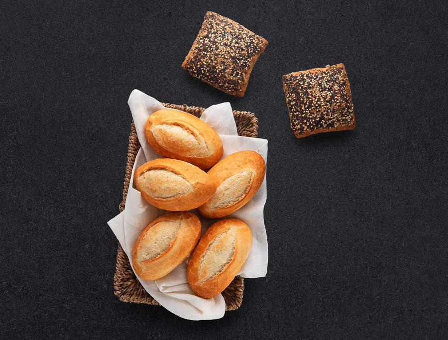 Food photography — bread rolls in wicker basket with sesame buns, bakery product photography